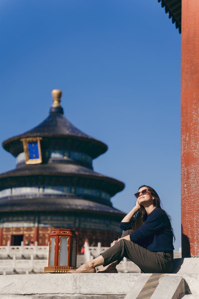 Mujer sentanda afuera de un templo en Beijing, China